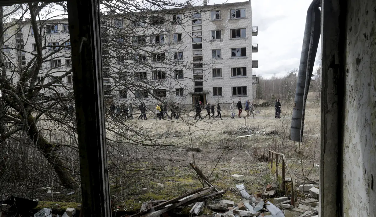 Sejumlah pengunjung menyusuri lokasi bekas kamp militer Uni Soviet di dekat Skrunda, Latvia (9/4).Karena keangkerannya tersebut banyak wisatawan yang tertarik mengunjungi tempat ini. (REUTERS/Ints Kalnins)