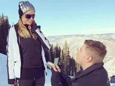 Aktor Chris Zylka berlutut menunjukkan cincin saat melamar pacarnya Paris Hilton di Pegunungan Aspen, Colorado, Amerika Serikat. Paris Hilton bertemu dengan Chris Zylka sejak enam tahun silam, tapi baru mulai menjalin cinta 2016. (Instagram/@parishilton)