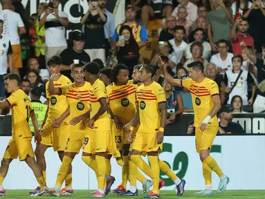 Pemain Barcelona, Robert Lewandowski (kanan) merayakan dengan rekan setimnya usai mencetak gol kedua timnya selama pertandingan sepak bola La Liga Spanyol melawan Valencia di stadion Mestalla, Spanyol, Sabtu 17 Agustus 2024 atau Minggu (18/8/2024) dini hari WIB. (AP Photo/Alberto Saiz)