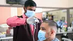 Seorang barber yang mengenakan masker memangkas rambut pelanggan di pasar Al-Mubarakiya di Kuwait City, Kuwait (18/8/2020). Kuwait mulai Selasa (18/8) memasuki tahap keempat dari rencana lima tahapnya untuk kembali ke kehidupan normal. (Xinhua/Ghazy Qaffaf)