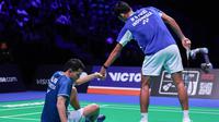 Ganda putar Indonesia&nbsp;Muhammad Shohibul Fikri membantu rekannya&nbsp;Fajar Alfian usai terjatuh pada laga semifinal Denmark Open&nbsp;2025 melawan pasangan&nbsp;China Liang Wei Keng/Wang Chang diJyske Bank Arena, Sabtu (18/10). (foto: PBSI)&nbsp;