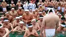Ekpresi para peserta saat berendam di kolam air dingin di Teppozu Inari Shinto Shrine di Tokyo, Jepang (8/1). Acara tersebut merupakan ritual musim dingin yang diyakini dapat menjaga kesehatan mereka. (AP Photo/Shizuo Kambayashi)