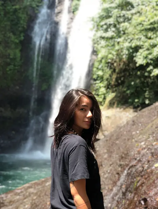 Perempuan berusia 30 tahun ini memang tetap terlihat memesona walaupun dengan gayanya yang santai. Berpose dengan latar belakang air terjun, ia tampak cantik menggunakan baju kaus hitam dengan rambut yang lurus. (Liputan6.com/IG/@itssheilamj)