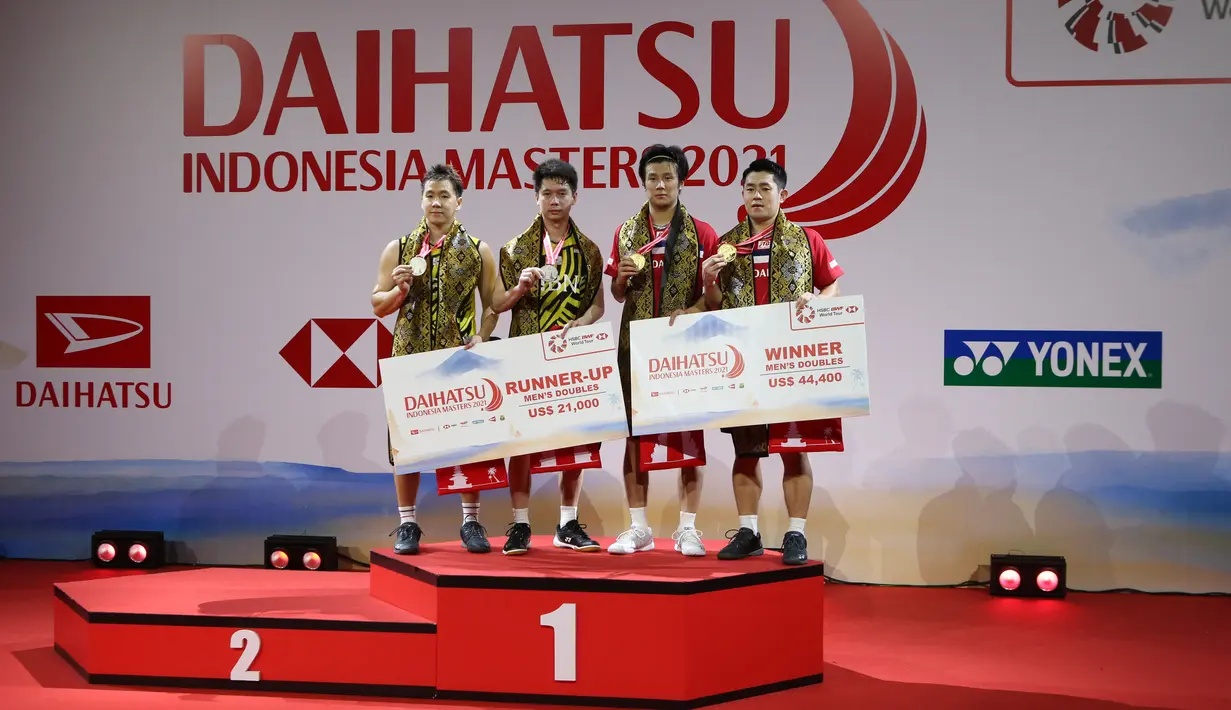 Pasangan ganda putra Jepang Takuro Hoki/Yugo Kobayashi (kanan) den pasangan ganda putra Indonesia Kevin Sanjaya Sukamuljo/Marcus Fernaldi Gideon berdiri di podium usai babak final Indonesia Masters 2021 di Nusa Dua, Bali, Minggu (21/11/2021). Kevin/Marcus kalah 11-21, 21-17, 19-21. (HUMAS PP PBSI)