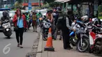 Warga melintas di samping trotoar yang dijadikan tempat parkir motor di Jalan Juanda, Bekasi, 4 Oktober 2016. Trotoar yang seharusnya untuk pejalan kaki ini dialih fungsikan oleh jasa parkir liar sebagai tempat parkir kendaraan bermotor. (Foto: Fajar)