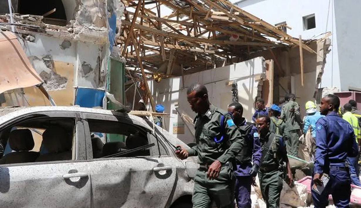 Petugas polisi mengecek sebuah mobil di lokasi serangan bom mobil di Distrik Hamarwayne, Mogadishu, Ibu Kota Somalia (4/2). Setidaknya sembilan orang tewas dan beberapa lainnya cedera akibat serangan bom mobil tersebut. (AFP Photo/Abdirazak Hussein Farah)