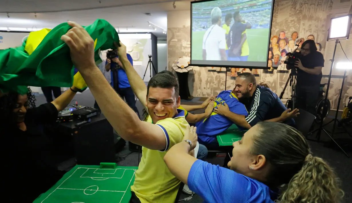 Carlos Junior bersuka cita saat Brasil memenangkan pertandingan melawan Meksiko di Sao Paulo, Brasil, (2/7). Junior bersama disabilitas lainnya menyaksikan pertandingan sepak bola dengan merasakannya dibantu oleh penerjemah. (AP Photo / Nelson Antoine)