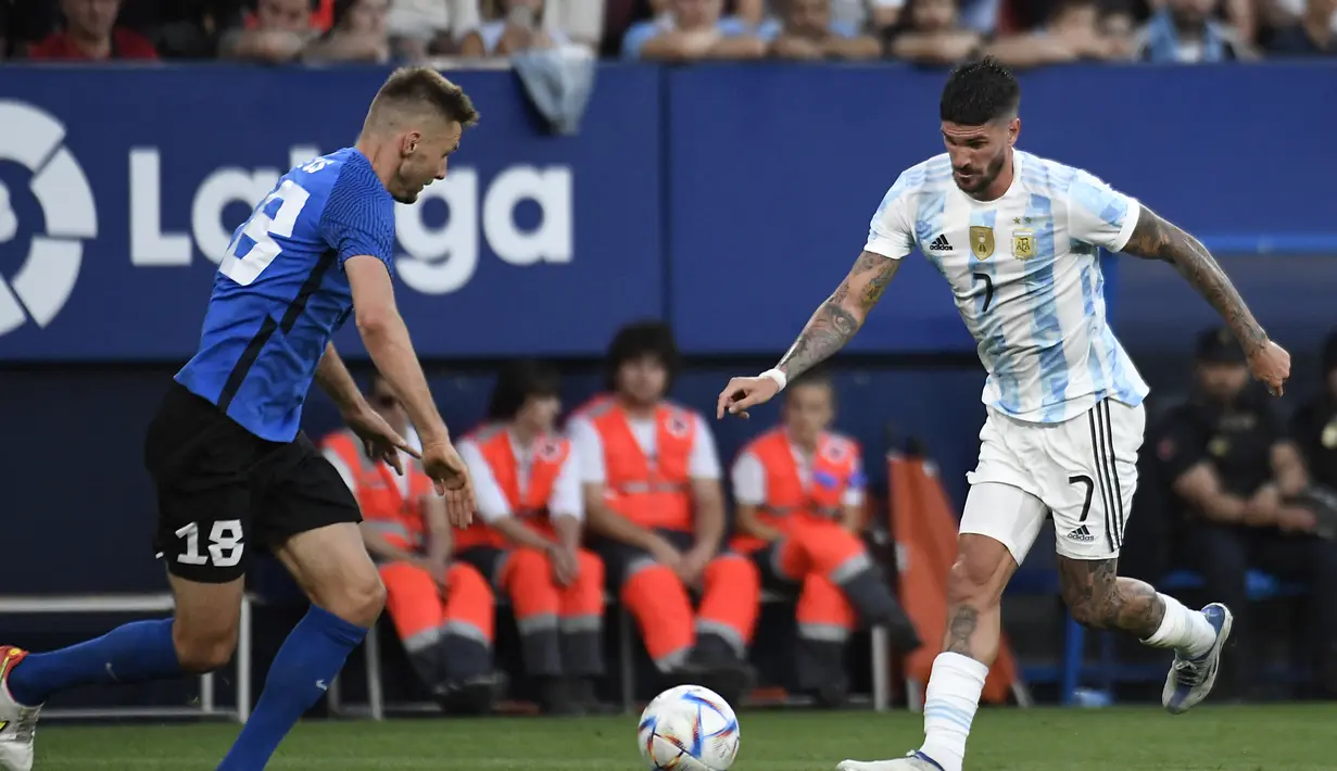 Gelandang Argentina, Rodrigo De Paul berusaha melewati bek Estonia, Karol Mets pada pertandingan persahabatan di stadion El Sadar di Pamplona, Spanyol utara, Senin (6/6/2022). Argentina menang besar atas Estonia 5-0. (AFP Photo/Ander Gillenea)