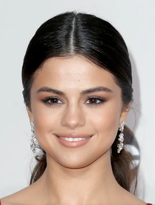 Hari itu Selena tampil mengenakan gaun panjang berwarna merah. Makeup yang diaplikasikan di wajahnya ditonjolkan pada bagian mata yang terlihat smokey dan tampak seksi. Ditambah gaya rambut ponytail membuat Selena terlihat fresh. (AFP/Bintang.com)