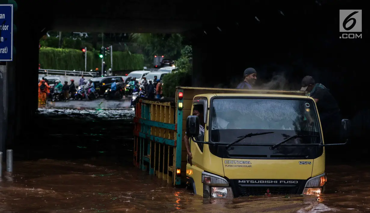 Truk berusaha menerobos banjir di terowongan Dukuh Atas, Jakarta, Senin (11/12). Akibat banjir setinggi satu meter tersebut, banyak kendaraan yang mogok, dan jalan tidak dapat diakses warga. (Liputan6.com/Faizal Fanani)