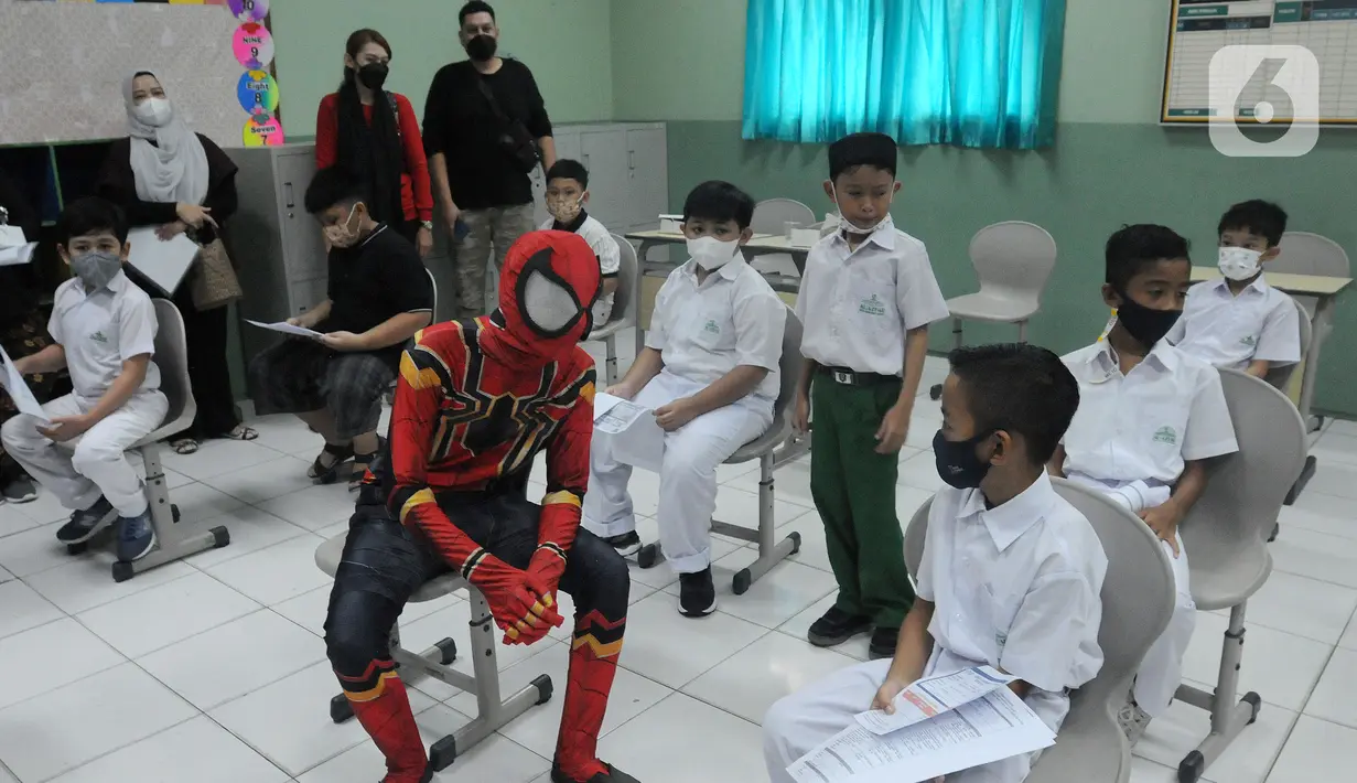 Spiderman berbincang dengan murid SD saat vaksinasi COVID-19 dosis kedua di Sekolah Al-Azhar, BSD, Tangerang Selatan, Banten, Senin (17/1/2022). Sebanyak 450 murid divaksin dengan melibatkan tokoh Spiderman untuk menghibur sekaligus menghilangkan rasa takut anak-anak. (merdeka.com/Arie Basuki)