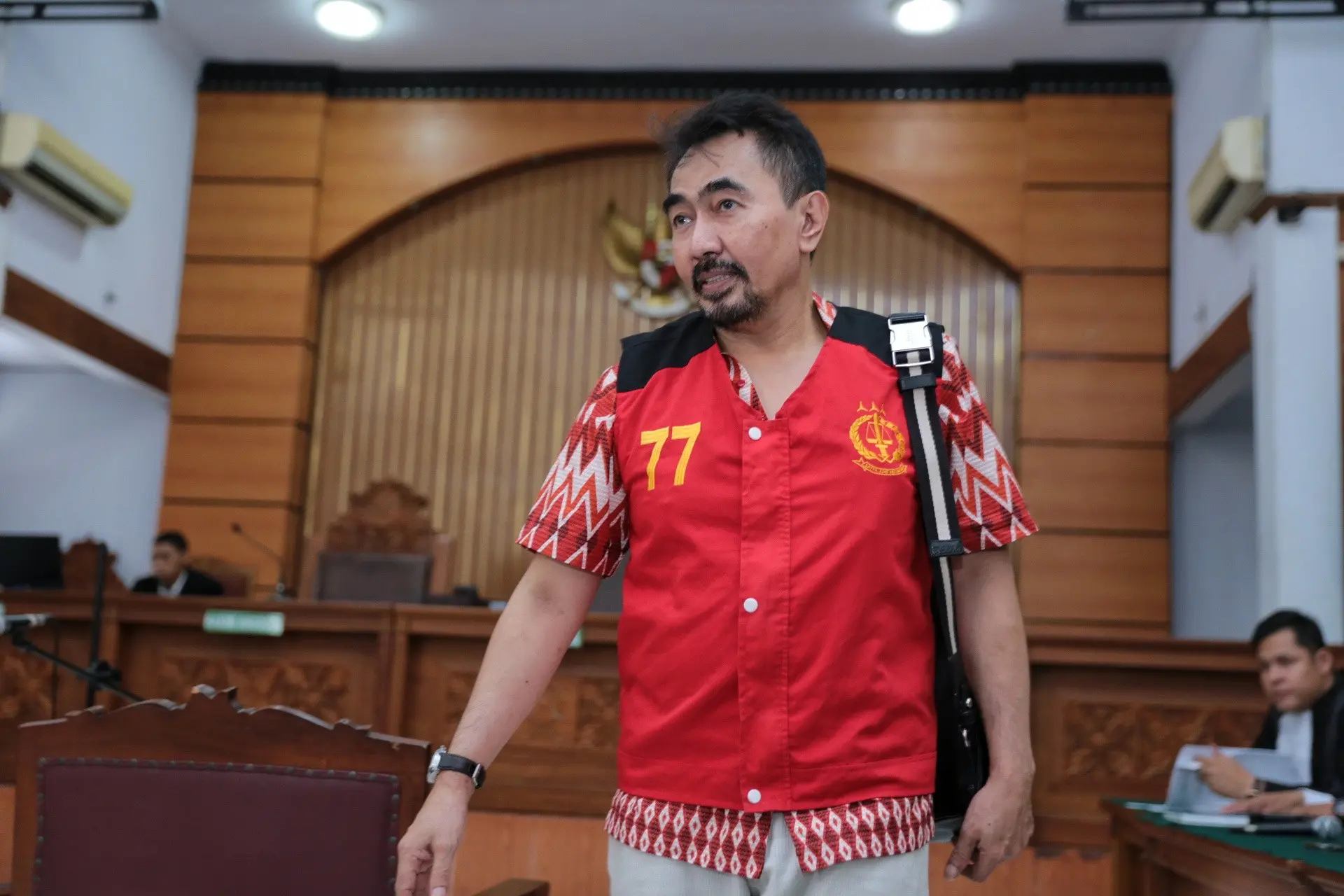Siang tadi, guru spiritual artis itu datang mengenakan rompi tahanan warna merah. Ia mengaku tergangu dengan kamera wartawan yang terus menyorotnya. (Adrian Putra/Bintang.com)