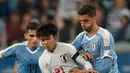 Gelandang Jepang, Takefusa Kubo berebut bola dengan gelandang Uruguay, Rodrigo Bentancur selama pertandingan grup C Copa America 2019 di Arena Gremio di Porto Alegre, Brasil (20/6/2019). Jepang bermain imbang 2-2 atas Uruguay. (AP Photo/Silvia Izquierdo)