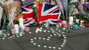 Bunga dan lilin diletakan setelah serangan bunuh diri di sebuah konser Ariana Grande di Albert Square, Manchester, Inggris, (23/5). Kepolisian Inggris menetapkan pelaku bom diri di konser Ariana Grande bernama Salman Abedi. (AP Photo/Kirsty Wigglesworth)