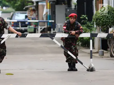 Anggota ormas kepemudaan berjaga di sekitar jalan menuju rumah penyidik Komisi Pemberantasan Korupsi (KPK) Novel Baswedan di kawasan Kelapa Gading, Jakarta, Kamis (22/2). Novel kembali ke tanah air dalam proses pemulihan. (Liputan6.com/Helmi Fithriansyah)