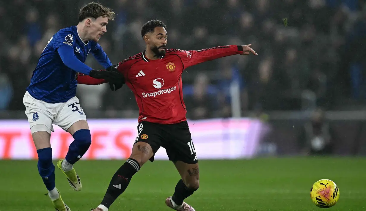 Hingga babak pertama usai, belum ada gol yang tercipta di laga ini. Kedua tim pun masuk ke ruang ganti dengan skor sama kuat 0-0. Tampak dalam foto, striker Manchester United, Matheus Cunha (kanan), menahan gelandang Everton asal Inggris, James Garner, selama pertandingan pekan ke-27 Liga Primer Inggris 2025/2026 di Stadion Hill Dickinson, Liverpool, barat laut Inggris, Senin 23 Februari 2026 waktu setempat atau Selasa 24 Februari 2026 dini hari WIB. (Paul ELLIS/AFP)