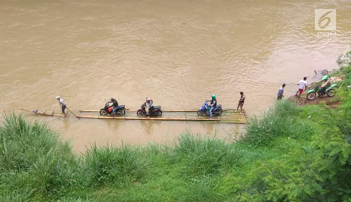 Pengendara roda dua memanfaatkan jasa perahu rakit untuk menyeberangi Sungai Cisadane di Rumpin, Bogor, Selasa (13/3). Akibat rusaknya jembatan akses  utama Rumpin-Ciseeng, warga menaiki perahu rakit dengan tarif Rp10.000. (Liputan6.com/Achmad Sudarno)