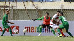 Kiper Madura United, Muhammad Ridho (memakai rompi) bersiap mengantisipasi bola dari ancaman pemain PSS Sleman dalam laga Grup C Piala Menpora 2021 di Stadion Si Jalak Harupat, Bandung, Selasa (23/3/2021). Madura United menang 2-1 atas PSS Sleman. (Bola.com/M Iqbal Ichsan)