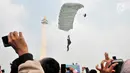 Penerjun payung bersiap mendarat saat Festival Damai Millenial Road Safety di Monas, Jakarta, Minggu (23/6/2019). Aksi puluhan penerjun payung TNI-Polri ini menjadi perhatian warga di akhir acara Festival Damai. (merdeka.com/Iqbal Nugroho)