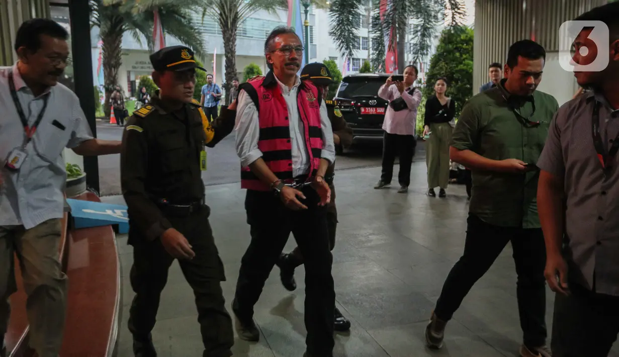 Dia yang telah mengenakan rompi tahanan merah muda dan tangan diborgol itu dibawa petugas menuju mobil tahanan. (Liputan6.com/Faizal Fanani)