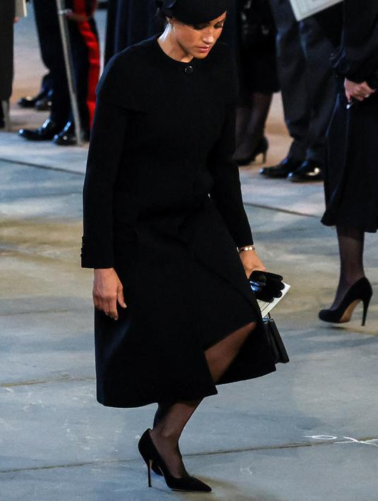 Meghan Markle saat memberikan penghormatan saat mengikuti prosesi persemayaman Ratu Elizabeth II di Westminster Hall di London (14/9/2022). (Photo by ALKIS KONSTANTINIDIS / POOL / AFP)