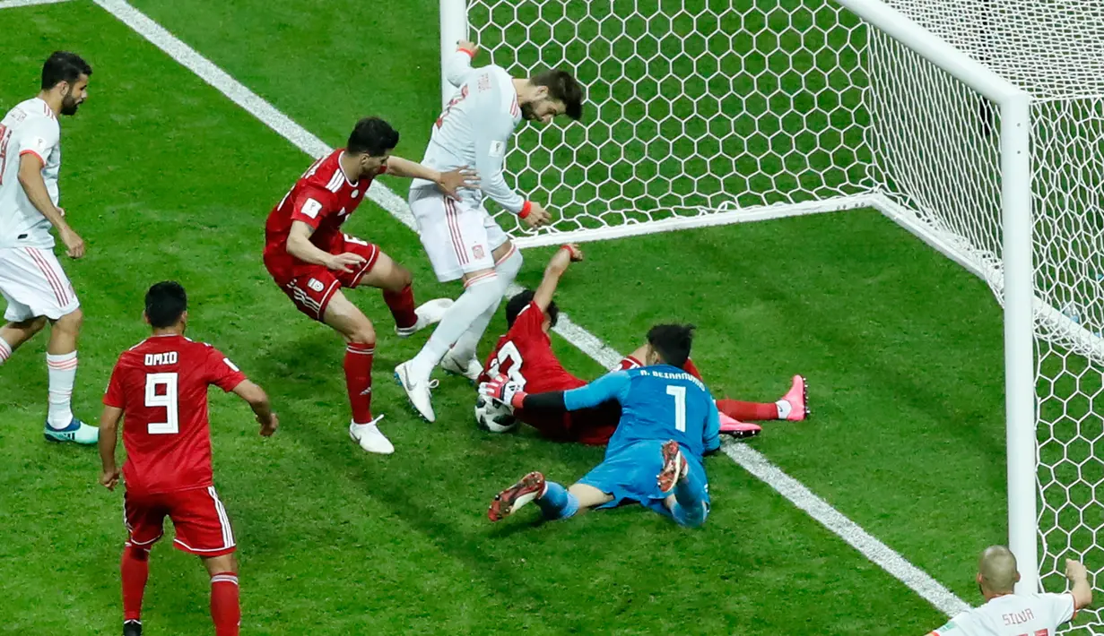 Pemain Spanyol, Gerard Pique (tengah) mencoba mencetak gol ke gawang Iran dalam penyisihan Grup B Piala Dunia 2018 di Kazan Arena, Kazan, Rusia, Rabu (20/6). Gol tunggal Diego Costa membawa Spanyol menumbangkan Iran. (AP Photo/Eugene Hoshiko)
