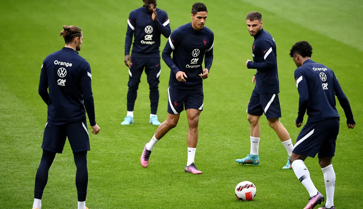 Bek Prancis Raphael Varane (tengah) dan Jonathan Clauss (kedua kanan) ambil bagian dalam sesi latihan menjelang laga persahabatan internasional, di stadion Pierre-Mauroy, Senin (28/3/2022). Prancis akan beruji coba melawan Afrika Selatan pada Rabu, 30 Maret 2022 dini hari WIB. (FRANCK FIFE / AFP)