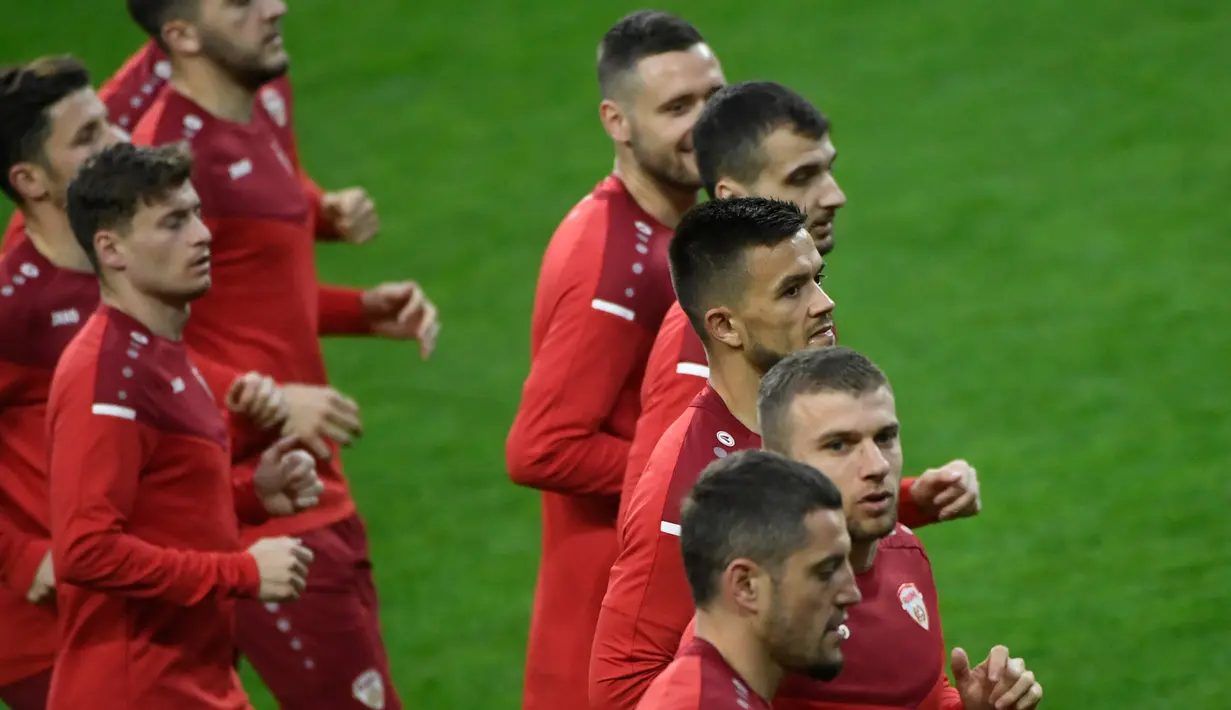 Bek Makedonia Utara Stefan Ristovski (kanan) berlari bersama timnya selama sesi latihan pada malam pertandingan play-off Piala Dunia 2022 di stadion Dragao di Porto, Senin (28/3/2022). Makedonia Utara akan menantang Portugal pada Rabu, 30 Maret 2022 dini hari WIB. (MIGUEL RIOPA/AFP)