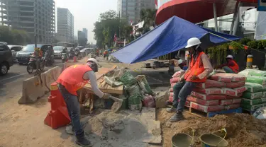 Pekerja menyelesaikan proyek pembangunan trotoar di Jalan MH Thamrin,Jakarta,Kamis (19/7). Jelang Asian Games 2018, pengerjaan infrastruktur di Jakarta terus dikebut. (Merdeka.com/Imam Buhori)