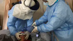 Pekerja medis memompa oksigen kepada pasien virus corona atau COVID-19 di sebuah rumah sakit di Wuhan, Provinsi Hubei, China, Minggu (16/2/2020). Sebanyak 1.770 orang dilaporkan meninggal akibat virus corona. (Chinatopix via AP)