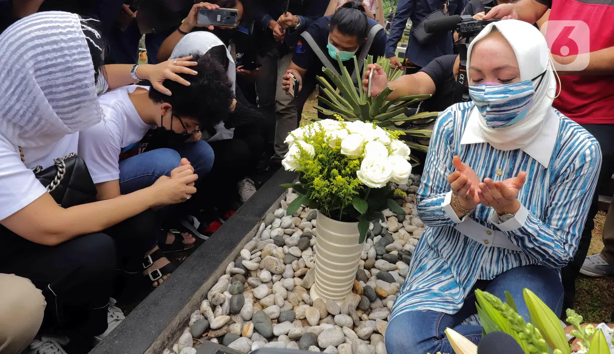 Mantan Anggota DPR Angelina Sondakh (kanan) bersama kedua anaknya Aaliyah Massaid dan Keanu Jabbar Massaid saat ziarah makam di TPU Jeruk Purut, Jakarta Selatan, Kamis (3/3/2022). Kedatangan mereka untuk berziarah ke makam Adjie Massaid dan bapak dari Adjie Massaid. (Liputan6.com/Herman Zakharia)