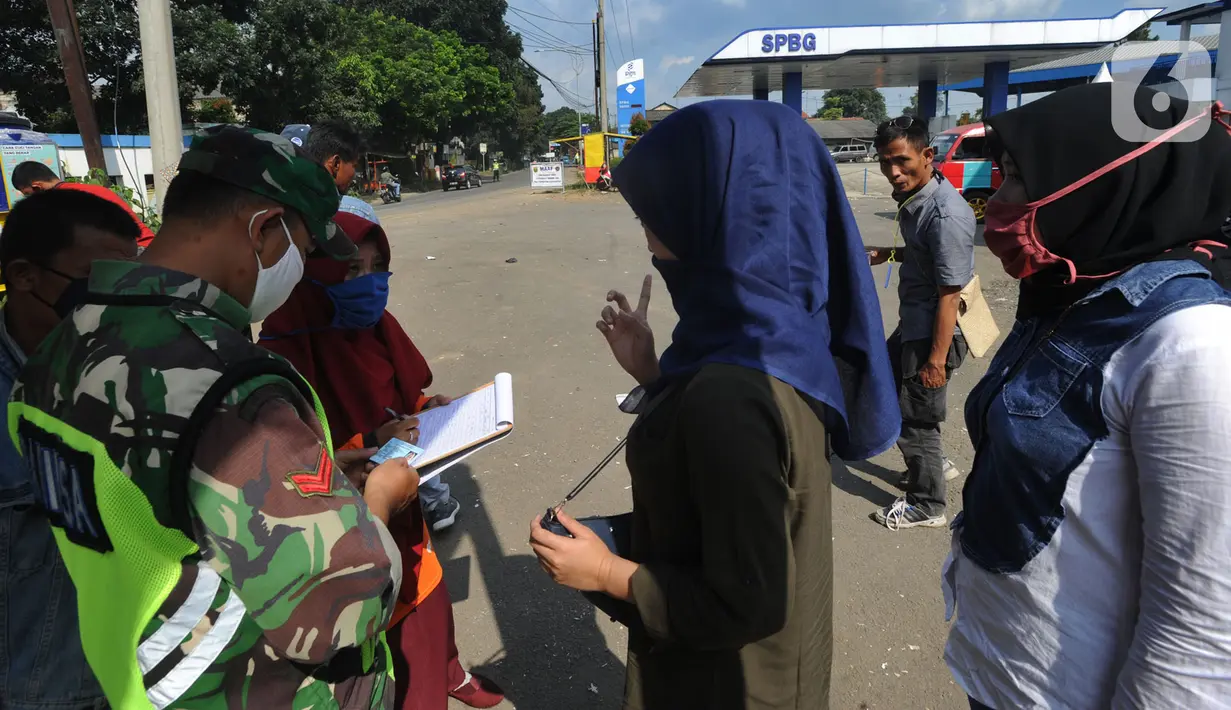 Tentara memeriksa identitas warga yang ingin menuju wilayah Sukabumi saat sterilisasi kendaraan di Terminal Cicurug, Sukabumi, Jawa Barat, Minggu (12/4/2020). Proses sterilisasi ini dilakukan untuk mencegah penyebaran virus corona COVID-19. (merdeka.com/Arie Basuki)