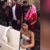 Seorang wanita terlalu asyik bermain game online dengan gaun pengantin. (Foto: istimewa)