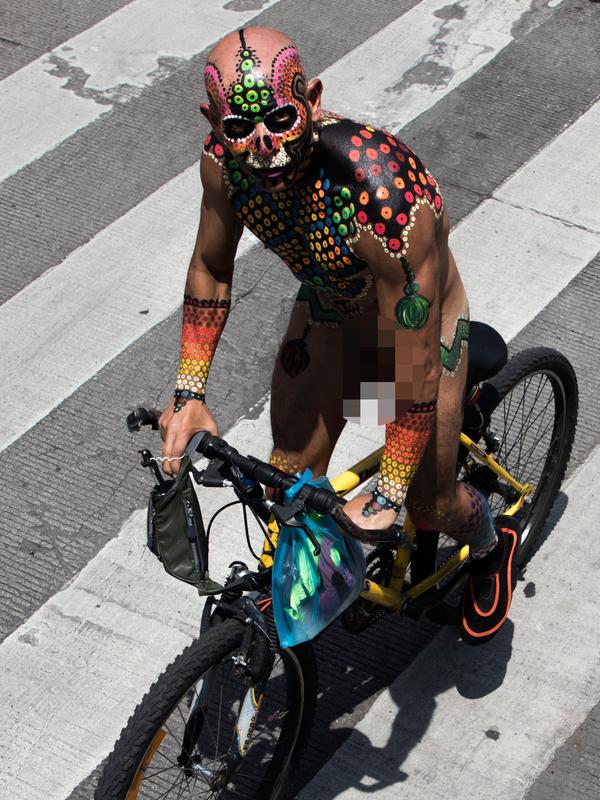 Seorang pria dengan tubuh di cat bersepeda keliling Kota Mexico City, Meksiko (8/6/2019). Rayakan World Naked Bike, ratusan warga tampil tanpa busana berkeliling pusat kota Meksiko. (AP Photo / Christian Palma)