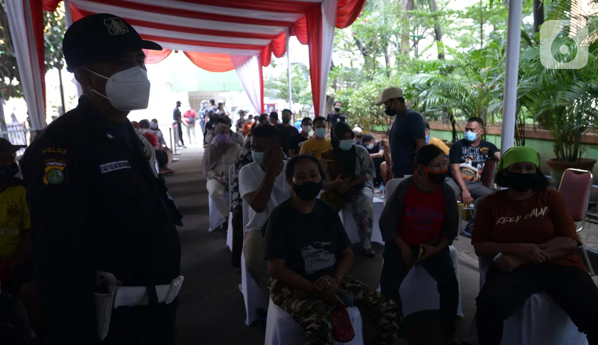 Petugas keamanan berjaga saat para pedagang menunggu untuk menjalani vaksinasi virus corona COVID-19 di Pasar Induk Kramat Jati, Jakarta Timur, Kamis (22/7/2021). Sebanyak 250 pedagang Pasar Induk Kramat Jati menjalani vaksinasi guna menekan penyebaran COVID-19. (merdeka.com/Imam Buhori)