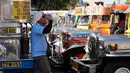 Seorang pengemudi jeepney beristirahat sambil minum air di terminal kota Pasay, Filipina, pada Senin, 23 Maret 2026. (AP Photo/Aaron Favila)