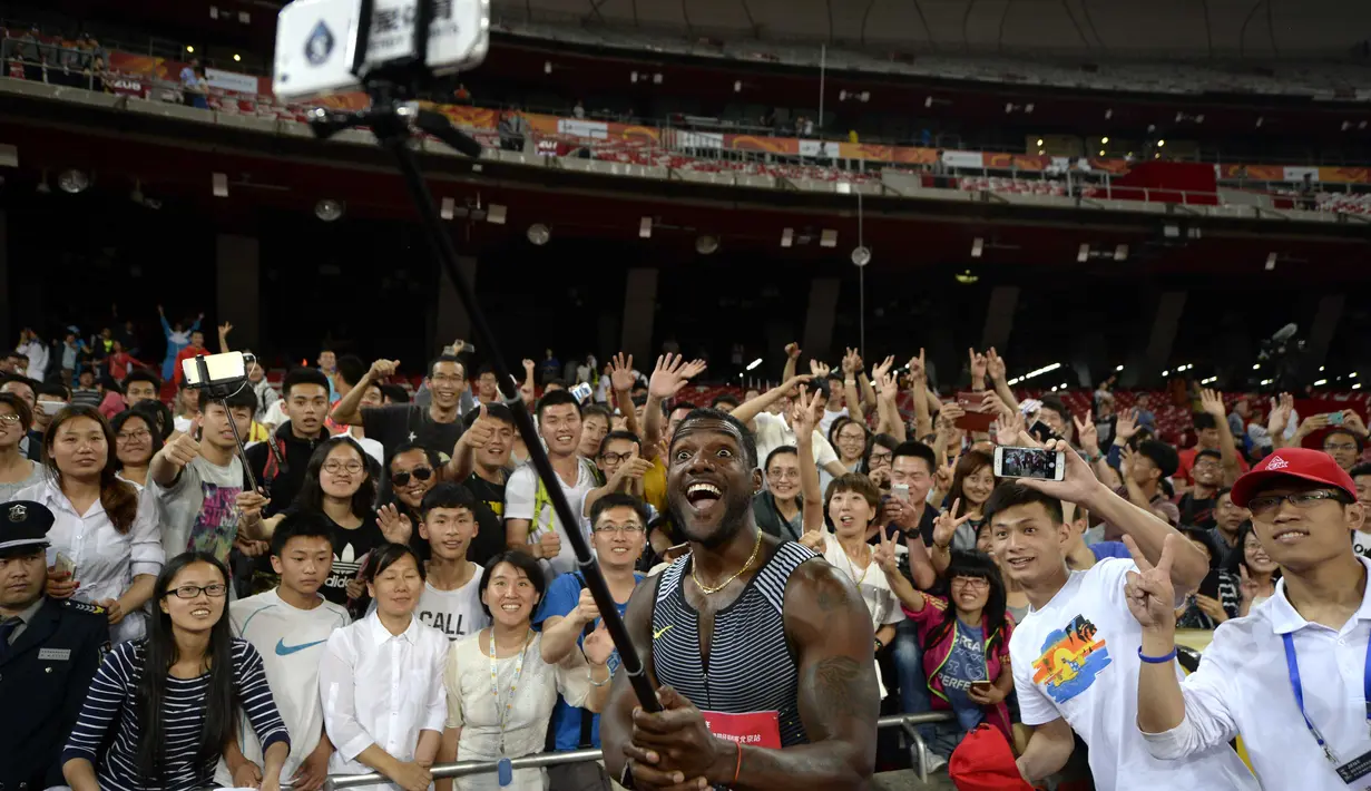 Pelari asal Amerika Serikat, Justin Gatlin berfoto selfie bersama ratusan fans usai lari menjuarai 100m putra pada kejuaraan IAAF World Challenge di National Olympic Stadium atau 'Birds Nest', Beijing, (18/5/2016). (AFP/Wang Zhao)