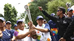 Wali Kota Banda Aceh Aminullah Usman (kiri), saat kirab Obor (torch relay) Asian Games di Banda Aceh, Selasa (31/7). Kirab Obor dimulai dari Museum Aceh dan berakhir di Kantor Gubernur Aceh. (Liputan6.com/Immanuel Antonius)