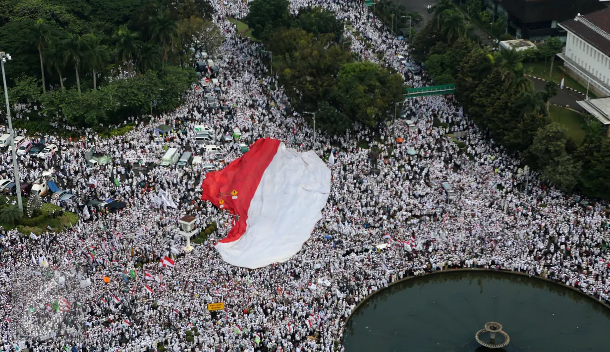 Sebuah bendera merah putih berukuran besar dibentangkan saat aksi damai di Bundaran Patung Kuda, Jakarta, Jumat (4/11). Massa menuntut  Gubernur Jakarta Basuki T Purnama agar diadili  atas dugaan penistaan agama. (Liputan6.com/Fery Pradolo)