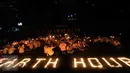 Puluhan karyawan Artha Graha Peduli menggelar aksi Earth Hours dengan menyalakan lilin di kawasan SCBD Jakarta, Sabtu (25/3) malam. Aksi tersebut sebagai bentuk kepedulian dalam mengurangi emisi gas rumah kaca di kawasan SCBD. (Liputan6.com/Fery Pradolo)