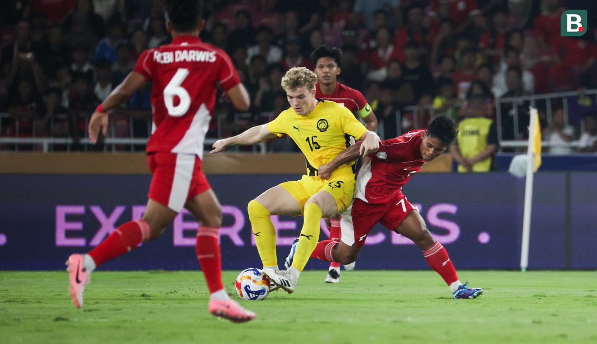 Pemain Timnas Indonesia U-23, Toni Firmansyah (kanan) berebut bola dengan pemain Malaysia, Fergus Tierney dalam laga Grup A Piala AFF U-23 2025 di Stadion Utama Gelora Bung Karno (SUGBK), Senayan, Jakarta, Senin (21/07/2025). (Bola.com/Abdul Aziz)