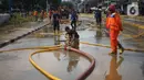 Suasana saat petugas Penanganan Prasaran dan Sarana Umum (PPSU) membersihkan lumpur yang mengendap di sepanjang Jalan Jatinegara Barat, Kampung Melayu, Jakarta Timur, Kamis (2/1/2020). Petugas melakukan bersih-bersih menyusul mulai surutnya banjir di kawasan itu.(Liputan6.com/Immanuel Antonius)