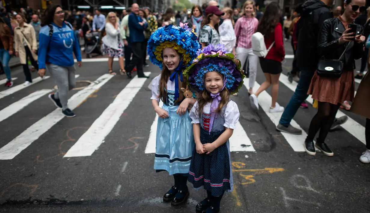 Dua gadis memakai topi bunga hias dalam Parade Paskah tahunan dan Festival Bonnet di sepanjang Fifth Avenue, New York, AS, Minggu (21/4). Parade Bonnet Easter merupakan parade pada perayaan Paskah di Kota New York yang sudah ada sejak tahun 1870. (Johannes EISELE / AFP)