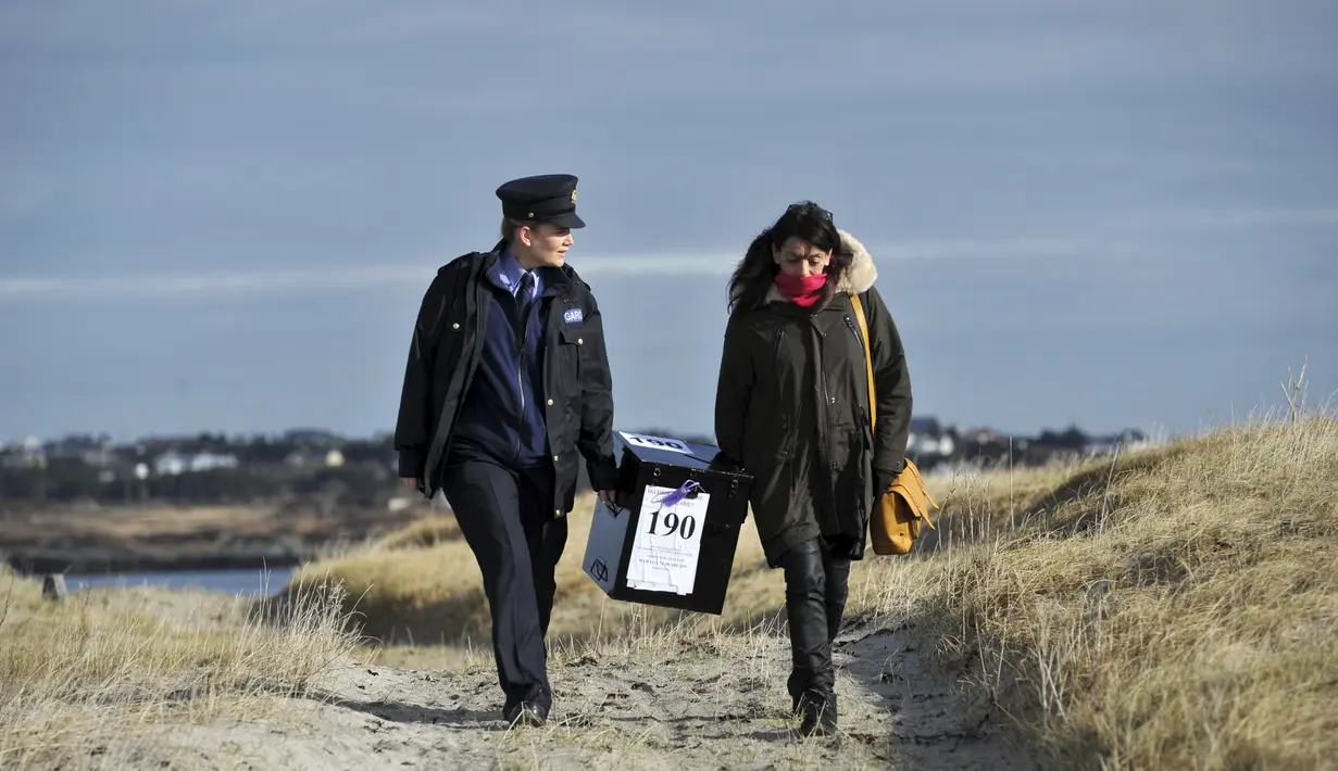 Polisi wanita Irlandia, Margaret Byrne dan pejabat ketua, Majella Harkin mengawal kotak suara ke pulau Innisfree, Irlandia, (25/2). Margaret seorang diri mengawal dan mengantarkan logistik pemilu ke pulau terpencil Irlandia. (REUTERS/Clodagh Kilcoyne)