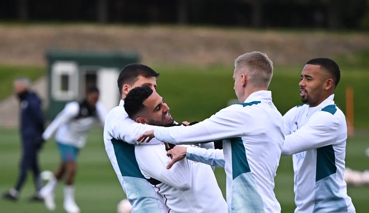 <p>(Dari kiri) Bek Manchester City, Aymeric Laporte, gelandang Riyad Mahrez, Oleksandr Zinchenko dan striker Gabriel Jesus bercanda saat mereka mengambil bagian dalam sesi latihan di tempat latihan Manchester City di Manchester, utara Inggris barat, pada 25 April 2022. Manchester City akan bertanding melawan Real Madrid. (AFP/Oli Scarff)</p>