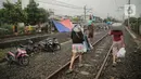 Tenda pengungsi banjir didirikan di jalur rel kereta commuterline Tangerang-Duri di Kembangan Baru, Jakarta, Jumat (3/1/2020). Jalur rel yang nonaktif sementara karena banjir dimanfaatkan warga sekitar untuk mendirikan tenda darurat karena rumah mereka masih terendam. (Liputan6.com/Faizal Fanani)