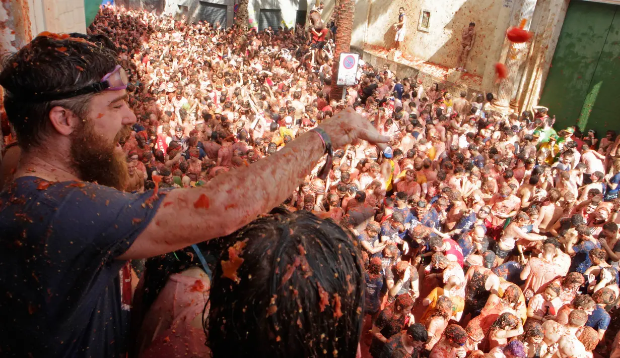 Puluhan ribu orang berkumpul pada festival La Tomatina di desa Bunol, Spanyol, Rabu (30/8). Lebih dari 20.000 peserta hadir di acara tahunan yang diselenggarakan setiap Rabu terakhir di bulan Agustus. (Alberto Saiz/AP)