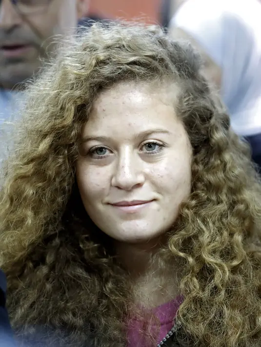 Ekspresi gadis remaja asal Palestina, Ahed Tamimi saat tiba di pengadilan militer Israel di penjara Ofer, Israel (13/2). Bagi warga Palestina, Ahed Tamimi memang dikenal sebagai gadis simbol perlawanan terhadap pendudukan Israel. (AFP/Thomas Coex)