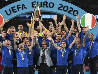 Para pemain Italia mengangkat trofi juara Euro 2020 usai mengalahkan Inggris pada pertandingan final di Stadion Wembley, London, Inggris, Minggu (11/7/2021). Italia menang 3-2 lewat adu penalti usai bermain imbang 1-1 di waktu normal. (Michael Regan/Pool via AP)