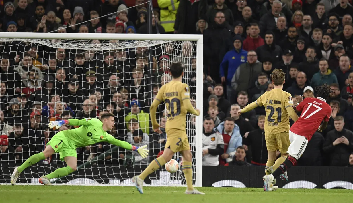 Pemain Manchester United, Fred (kanan) menendang bola ke gawang Barcelona yang membuahkan gol dalam pertandingan leg kedua play-off babak gugur Liga Europa 2022/2023 yang berlangsung di Old Trafford, Jumat (24/2/2023) WIB. (AFP/Oli Scarff)
